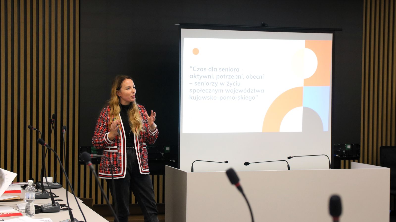 zdjęcie osoba stoi przy ekranie projekcyjnym i prowadzi wykład