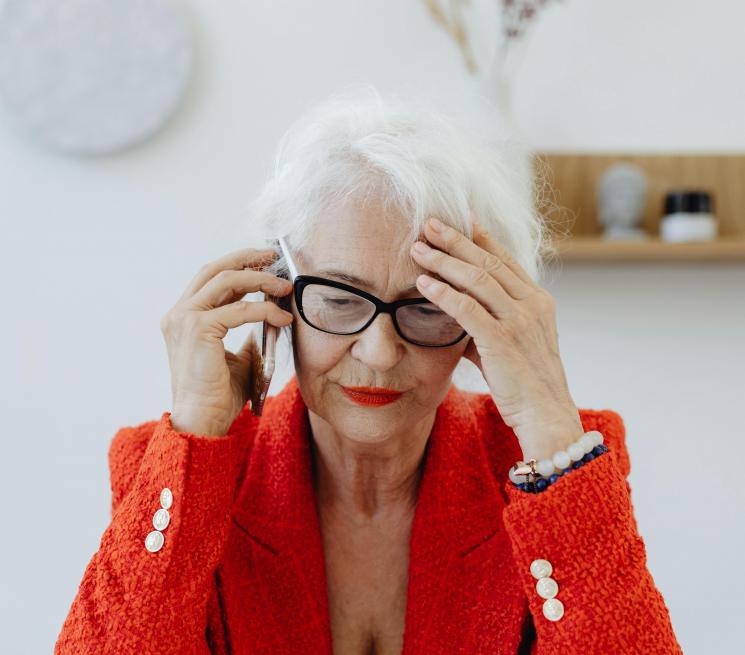 zdjęcie starsza kobieta rozmawia zmartwiona przez telefon