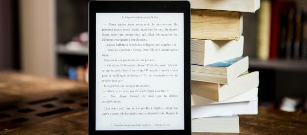 czytnik ebook oparty o stos książek