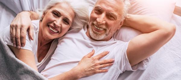 para seniorów leży w łóżku przytulowa patrzy do góry