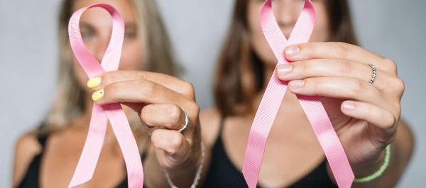 zdjęcie dwóch koebit trzymających różowe wstążki