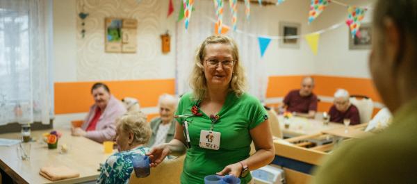 opiekunka roznosi jedzenie w placówce opiekuńczej dla seniorów