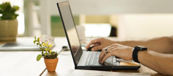 zdjęcie dłonie mężczyzny piszącego na klawiaturze laptopa