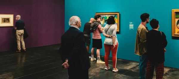 zdjęcie osoby oglądają obrazy na wystawie malarskiej w muzeum