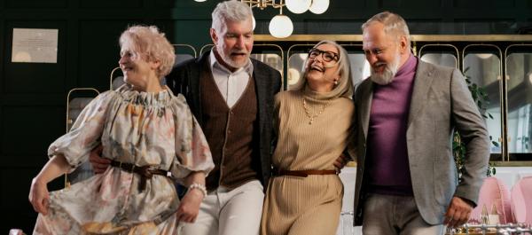 zdjęcie dwie pary seniorów trzymają się w pasie i tańczą w kawiarni
