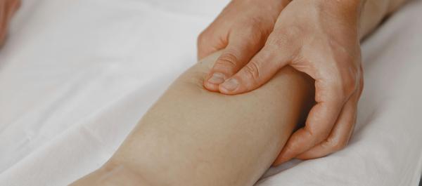 zdjęcie fizjoterapeuta masuje nogę pacjentowi