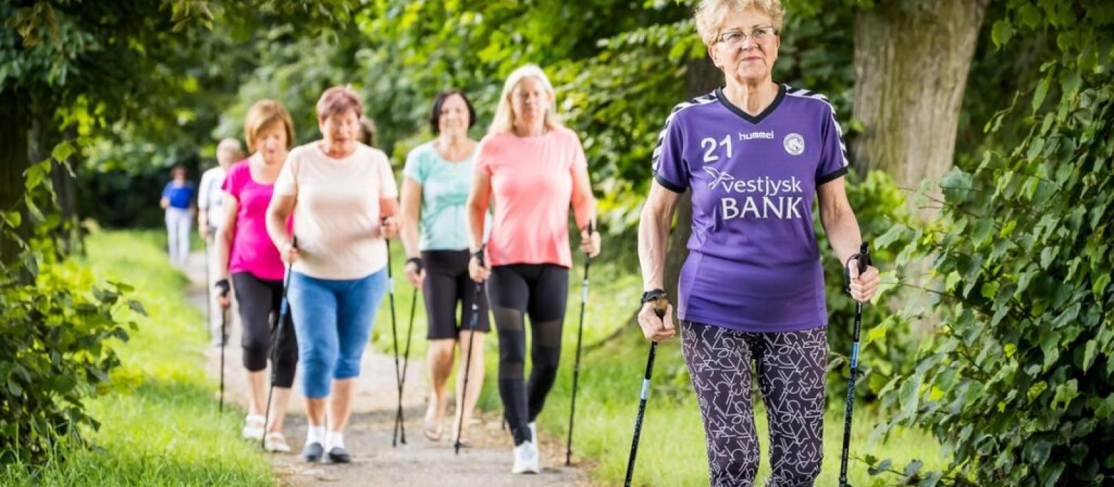 zdjęcie kilka starszych pań uprawia nordic walking w park