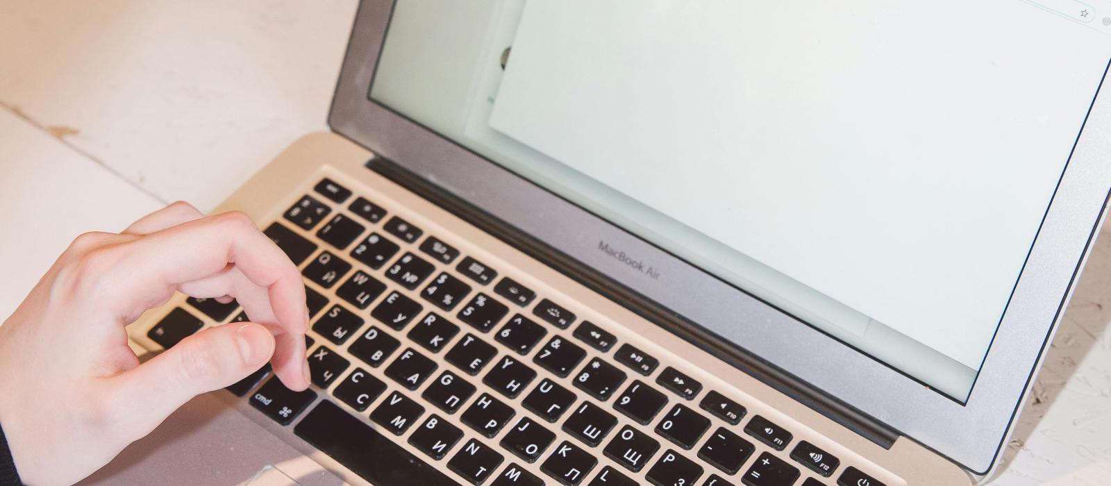 zdjęcie dłonie piszące maila na klawiaturze laptopa