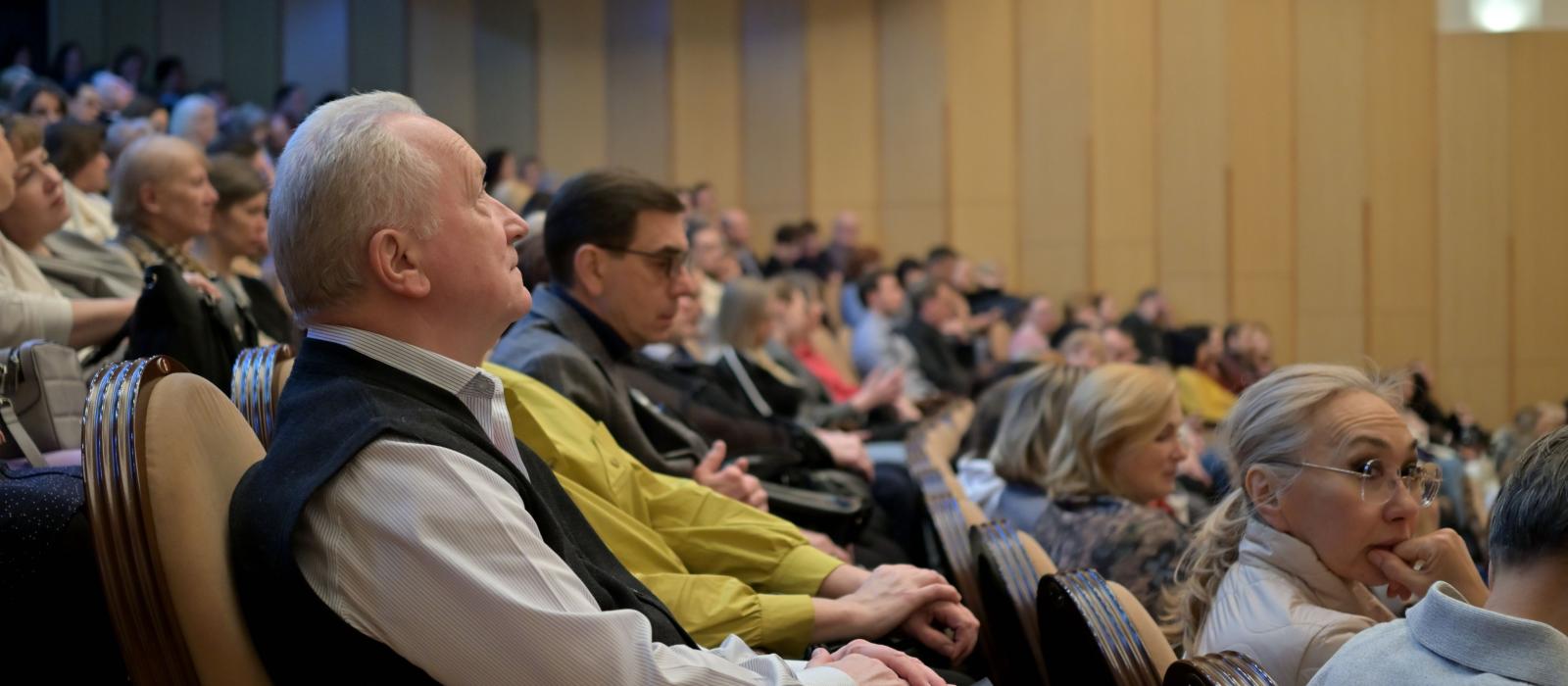 zdjęcie sala aula pełna ludzi osoby siedzą w rzędach krzeseł